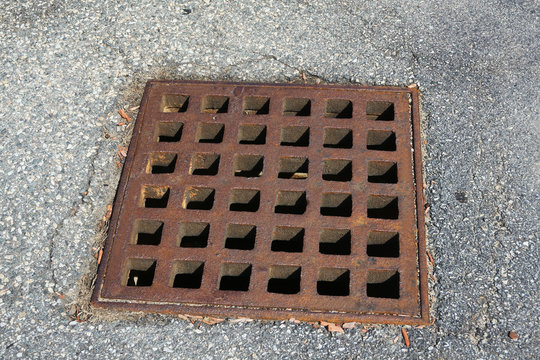 rustic square manhole drain cover in the street