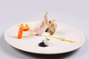 chicken breast with vegetables on a white plate.