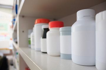 medicine bottles arranged on shelf at drugstore