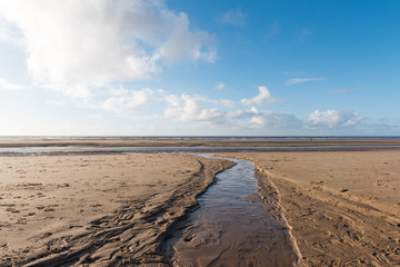 Beautiful blue sky and textured sand, on a cool sunny winters day at the beach