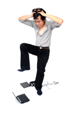 Young asian businessman trying to crunch his laptop