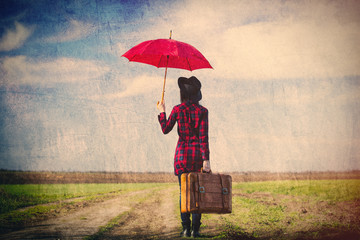 photo of young woman with suitcase and umbrella