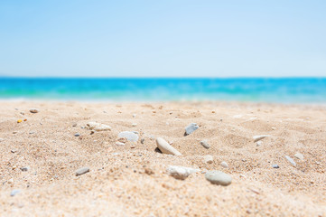 Fototapeta na wymiar Blurred background with white sand and blue sea