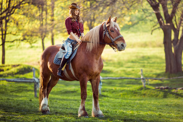 Obraz premium Beautiful girl riding horse on summer field