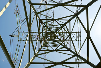 A high voltage electricity pylon against blue sky.