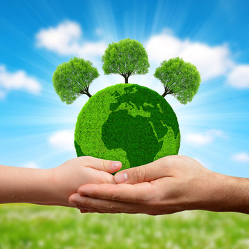Green planet with trees in hands. Earth day concept.