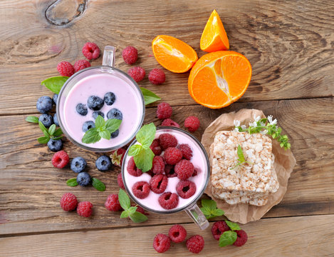 Breakfast. Yogurt with berries blueberries and raspberries, slices and ripe orange.Healthy eating.