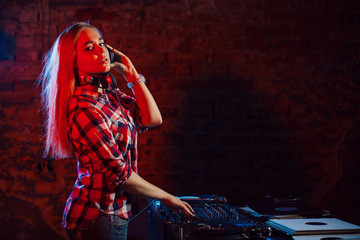 Cute dj woman having fun playing music at club party