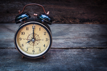 Still life with alarm clock on wood table.