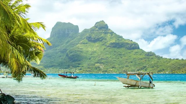 Exotic South Pacific Setting in Bora Bora French Polynesia with Local Fishing Boats in Tropical Blue Water and Epic Mountain Background