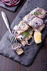 Sliced herring on a black slate plate