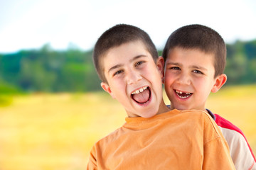beautiful funny young smiling brothers play outdoor in countryside
