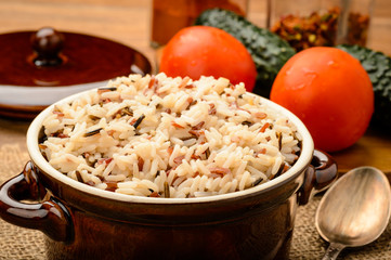 Boiled rice in ceramic bowl on wooden table.