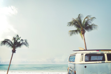 Oldtimer geparkt am tropischen Strand (Meer) mit Surfbrett auf dem Dach - Freizeitausflug im Sommer