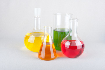 Colored liquid inside laboratory bulbs on white background