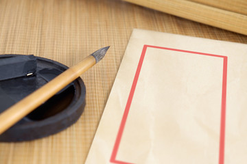 Chinese writing brush / Chinese writing brush and ink for calligraphy and envelope placed on bamboo background.