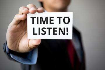 Businessman presenting 'Time To Listen' word on white card