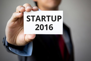 Businessman presenting 'Start up 2016'' word on white card
