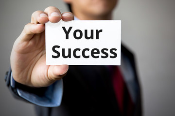 Businessman presenting 'Your Success' word on white card