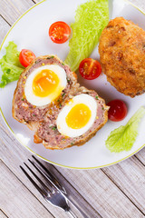 Scotch Eggs Served with Tomato Cherry and Salad on White Plate. View From Above, Top Studio Shot
