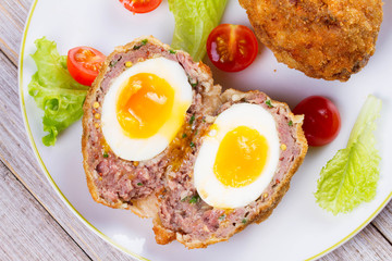 Scotch Eggs Served with Tomato Cherry and Salad on White Plate. View From Above, Top Studio Shot