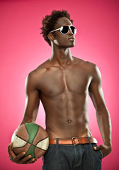 handsome black man naked with jeans and basket ball isolated on grey