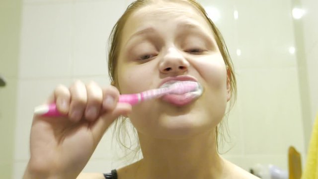 Teen girl brushes her teeth, 4K