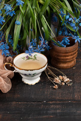 Obraz na płótnie Canvas Tea with lemon and bouquet of blue primroses on the table