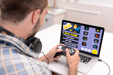 Fototapeta na wymiar Young man playing computer games at home