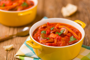 Delicious letcho with fresh vegetables, served in a yellow pot w