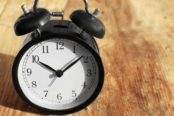 Alarm clock on old wooden table.