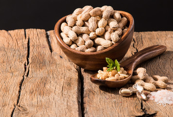 Peanuts in wooden bowl with black background