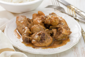 boiled chicken with beer sauce in white plate and rice in bowl on white background