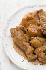 boiled chicken with beer sauce in white plate on white wooden background