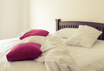 Morning view of an unmade bed in vintage color effect