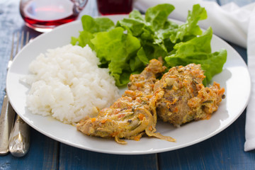 rabbit with boiled rice and salad on white plate