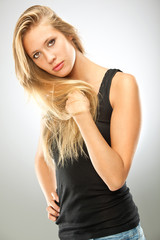 Fototapeta premium beautiful blonde serious girl black dressed isolated on grey