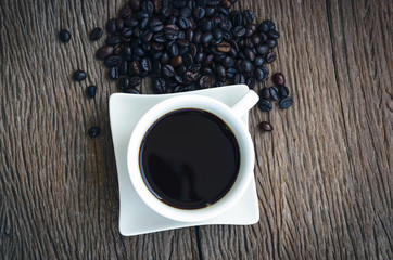 Coffee cup and offee bean top view on  wooden background.