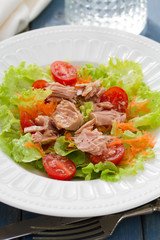 fish salad on white plate on blue background