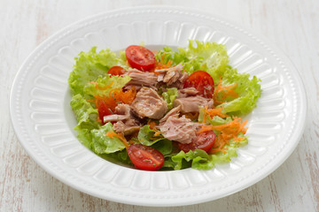 tuna salad on white plate on white wooden background
