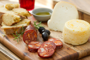 smoked sausage, cheese, bread and glass of red wine