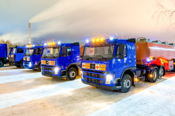 trucks for dangerous materials at night with flashing beacons
