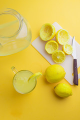 Water and lemon in yellow background