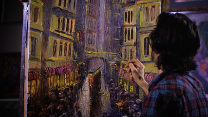 Obraz na płótnie Canvas An artist painting with a palette knife in studio