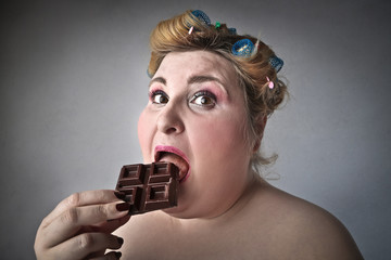 Chubby woman eating chocolate