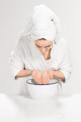 Young woman washing face with clean water