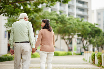Fototapeta premium Aged couple holding hands when walking in the park