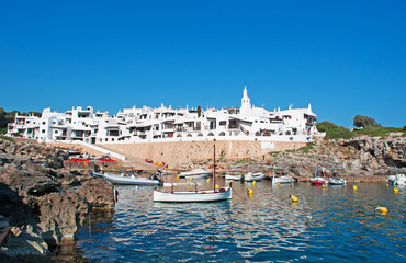 Minorca, isole Baleari, Spagna: il villaggio di pescatori di Binibeca Vell il 10 luglio 2013. Il villaggio bianco fu progettato dall’architetto spagnolo Antonio Sintes nel 1972 - obrazy, fototapety, plakaty