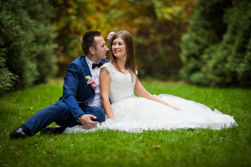 elegant stylish groom with his happy gorgeous brunette bride on