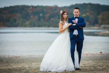 elegant stylish groom with his happy gorgeous brunette bride on